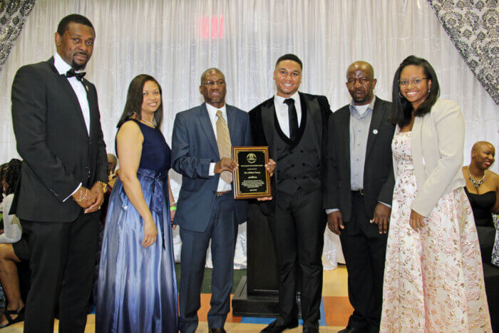 Dr. Clifford Yong, with plaque, flanked by family members and Consul General Rondy "Luta" McIntosh (far left).