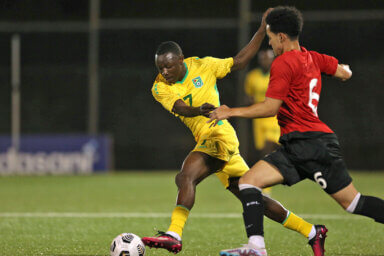BRIDGETOWN, BARBADOS. MARCH 28th: Omari Glasgow #7 of Guayana competes for the ball with Lucas Kirnon #6 of Montserrat during the League B - Group B match between Guyana and Montserrat in the 2022/23 Concacaf Nations League, held at the Wildey Turf Stadium, in Bridgetown, Barbados.