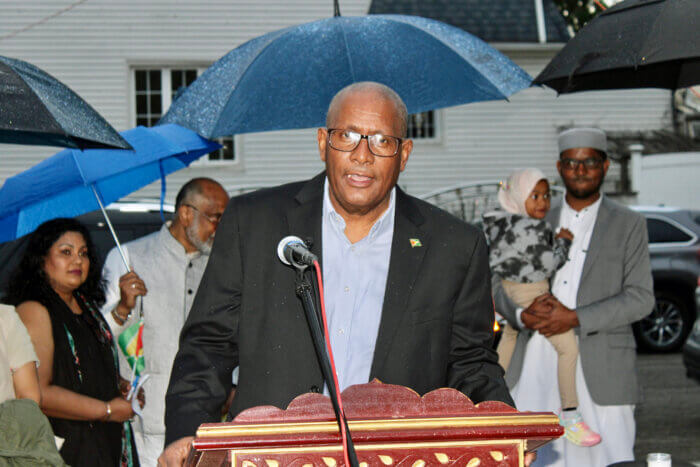 Consul General Michael E. Brotherson addressing a gathering at Smokey Park, Richmond Hill, who are grieving the loss of 19 children, lost in a fire at their dormitory in Mahdia, Region 8, Guyana.