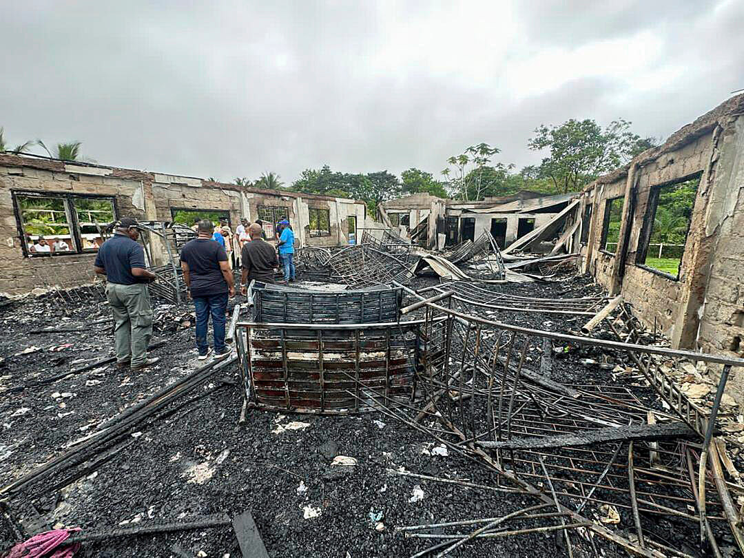 In this photo provided by Guyana's Department of Public Information, the dormitory of a secondary school is burned in Mahdia, Guyana, Monday, May 22, 2023. A nighttime fire raced through the dormitory early Monday, killing at least 19 students and injuring several others, authorities said.