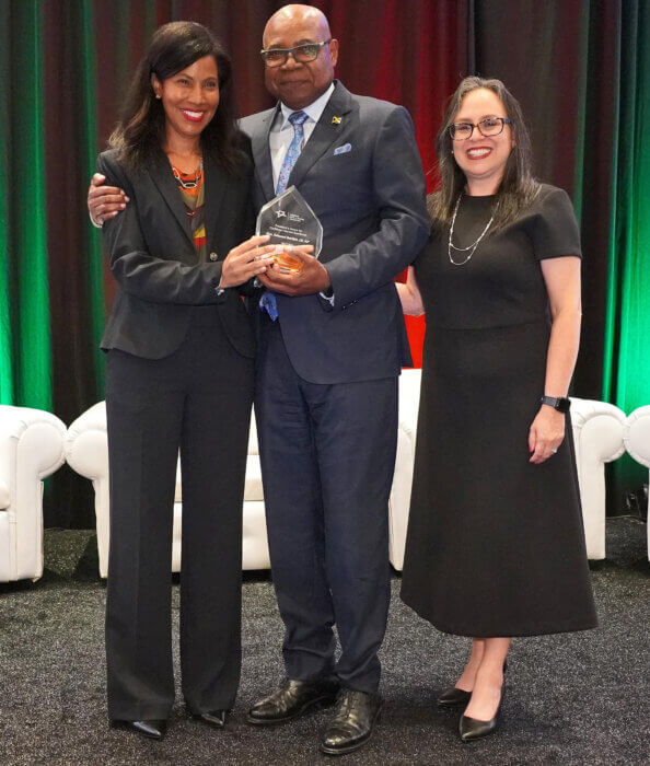 Minister of Tourism, Edmund Bartlett (C) accepts the President’s Award for Caribbean Excellence in Tourism from President of the Caribbean Hotel and Tourism Association (CHTA), Nicola Madden-Greig (L). Sharing in the moment is Vanessa Ledesma-Berrios, acting CEO & director general CHTA.