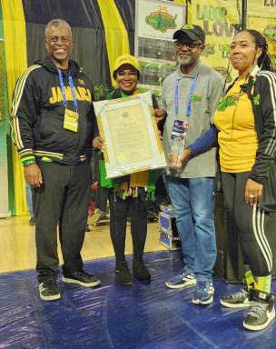 Consul General Alsion Wilson presenting award to Irwine Clare. Also in picture are Dr. Anthony Munroe, President BMCC and Stacey Osbourne, of Team Jamaica Bickle.