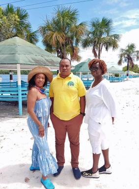 From Left, New Yorker Claire, Marketing Manager of Lake Mainstay Resort, Roy Moore, and Brooklyn resident Gillian pose on the white sandy beach of Lake Mainstay/Whyaka Resort, Essequibo county.