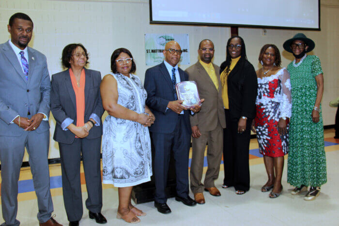 Pastor Robert McBarnett, fourth from left, holding plaque to present to Pastor Joseph, to his immediate left, with members of SMCI and SVG Consul General Rondy "Luta" McIntosh, far left.