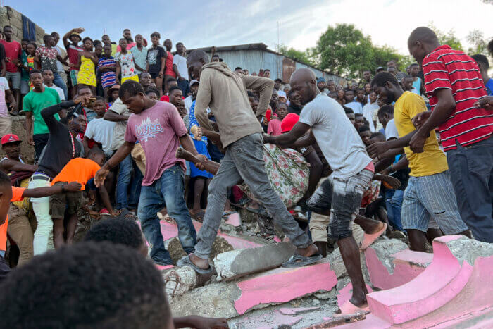 People carry an injured person away from a home that collapsed due to an earthquake in Jeremie, Haiti, Tuesday, June 6, 2023.