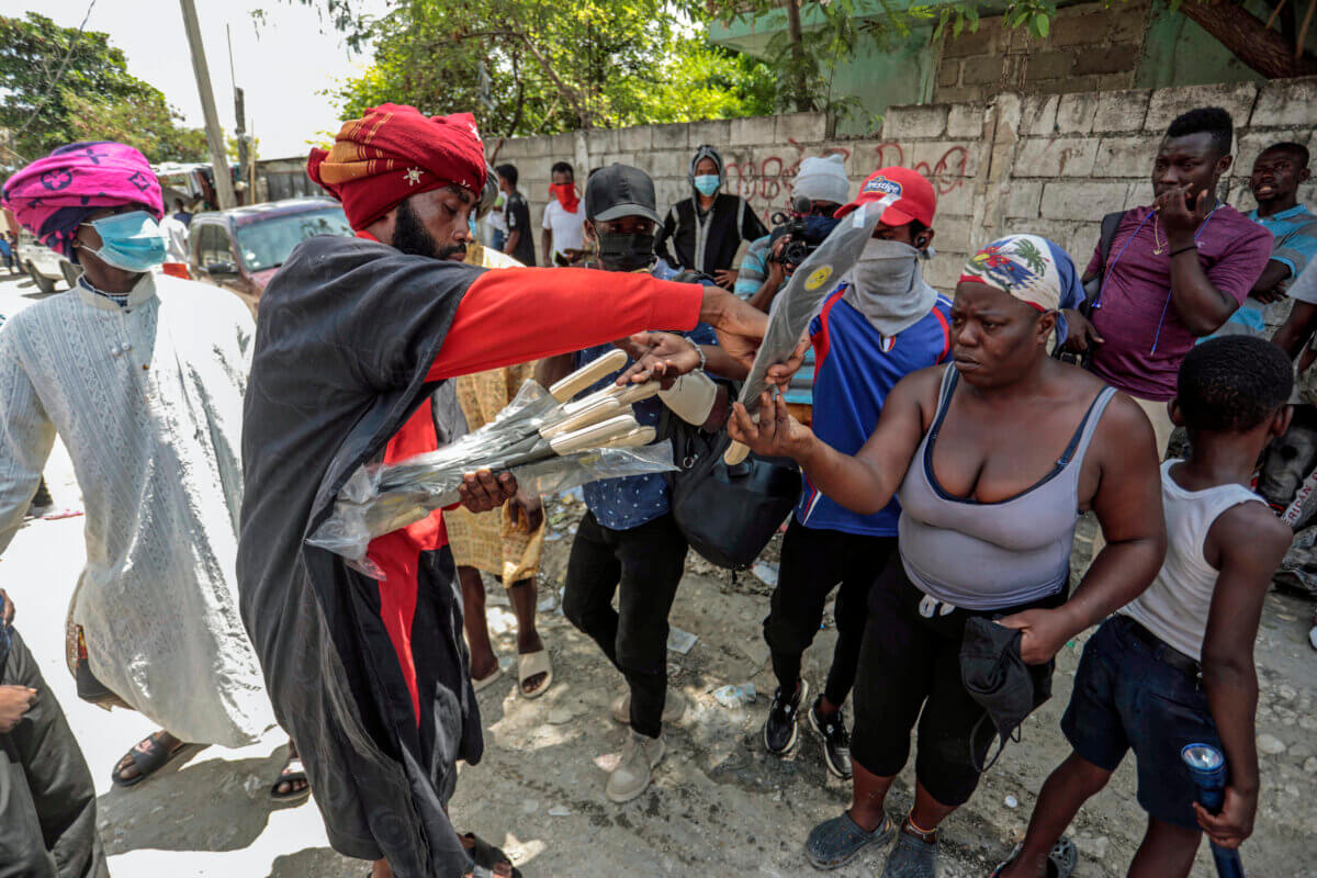 Nertil Marcelin, leader of a community group, distributes machetes to residents in an initiative to resist gangs seeking to take control of their neighborhood, in the Delmas district of Port-au-Prince, Haiti, Saturday, May 13, 2023.