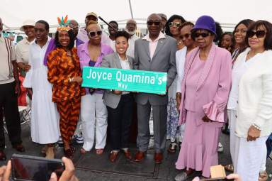 Derek Ventour, center, with Michelle Quamina, Congresswoman Yvette D. Clarke, Council Member Crystal Hudson and family members with replica of Joyce Quamina's Way street sign. 