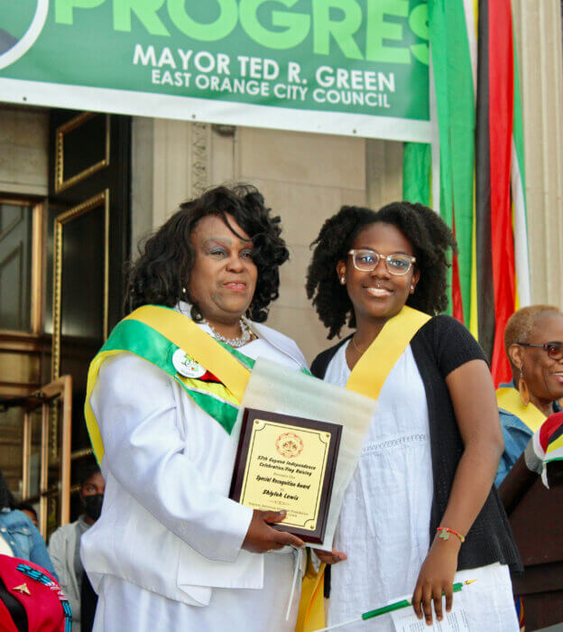 Twelve-year-old Shiyloh Lewis accepting an award from Lady Ira Lewis, her grandmother, for her outstanding community work and educational pursuits.