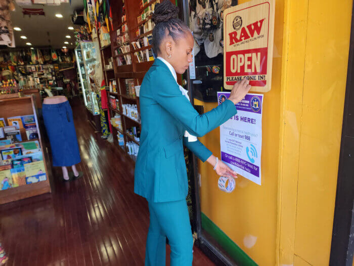 Assemblywoman Monique Chandler-Waterman puts up and distributes posters at local businesses.