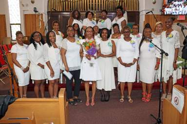 UVOP President and Director Sophia Eversley, center, with bouquet of flowers, flanked by UVOP members.