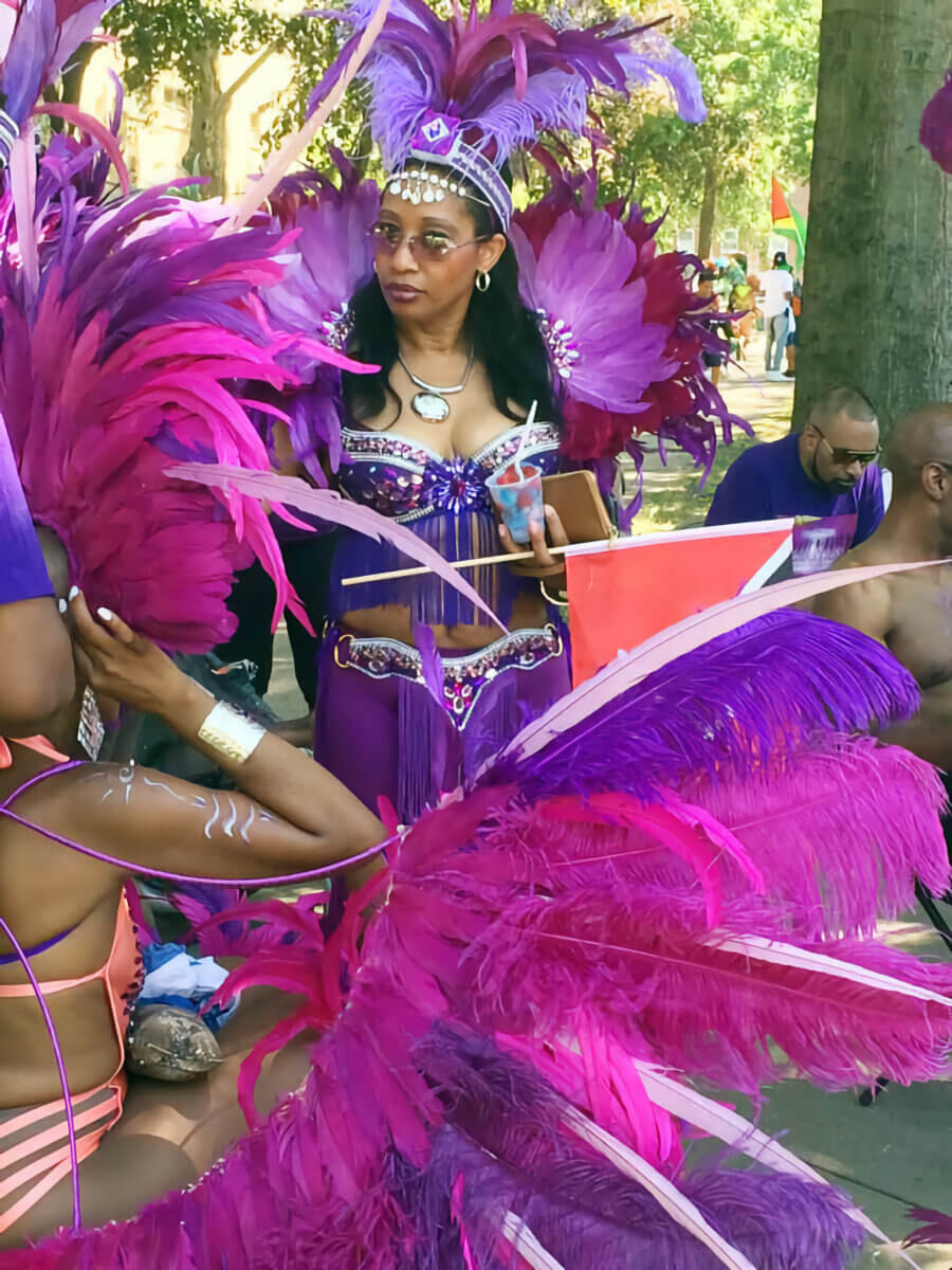 A reveler decked out in a colorful costume at Lincoln Park, Jersey City in preparation to play mas at the Jersey City Caribbean Carnival in 2016.