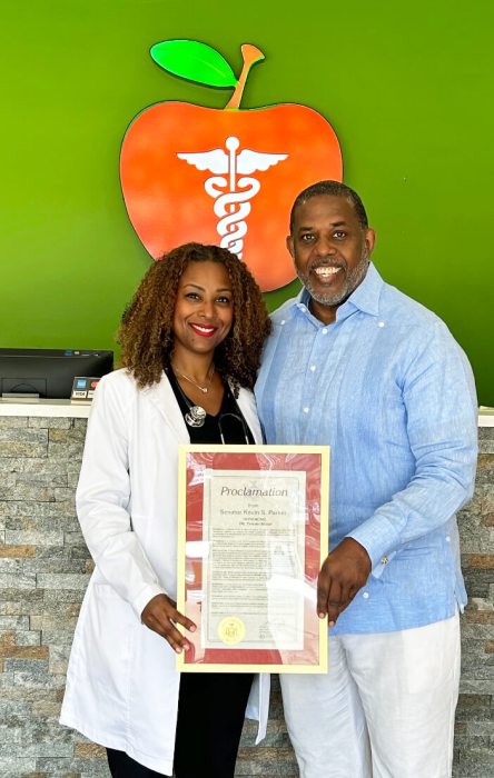 Dr. Moise, co-founder/CEO and medical director of the esteemed Big Apple Urgent Care in Brooklyn, left, was presented with a proclamation from NYS Senator Kevin Parker.