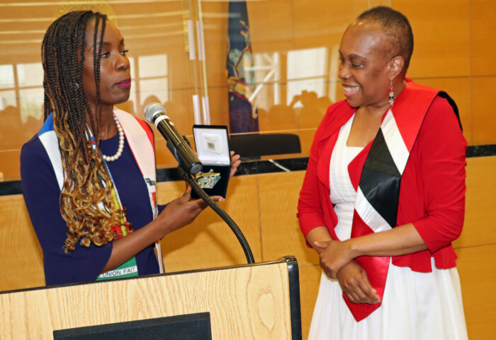 Natasha Delille, Esq. (left) presents an award to Justice Wavny Toussaint.