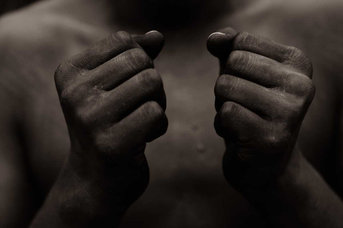 Black person holding fist in front of chest