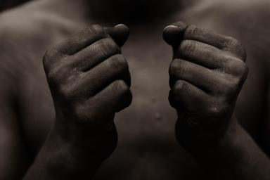 Black person holding fist in front of chest