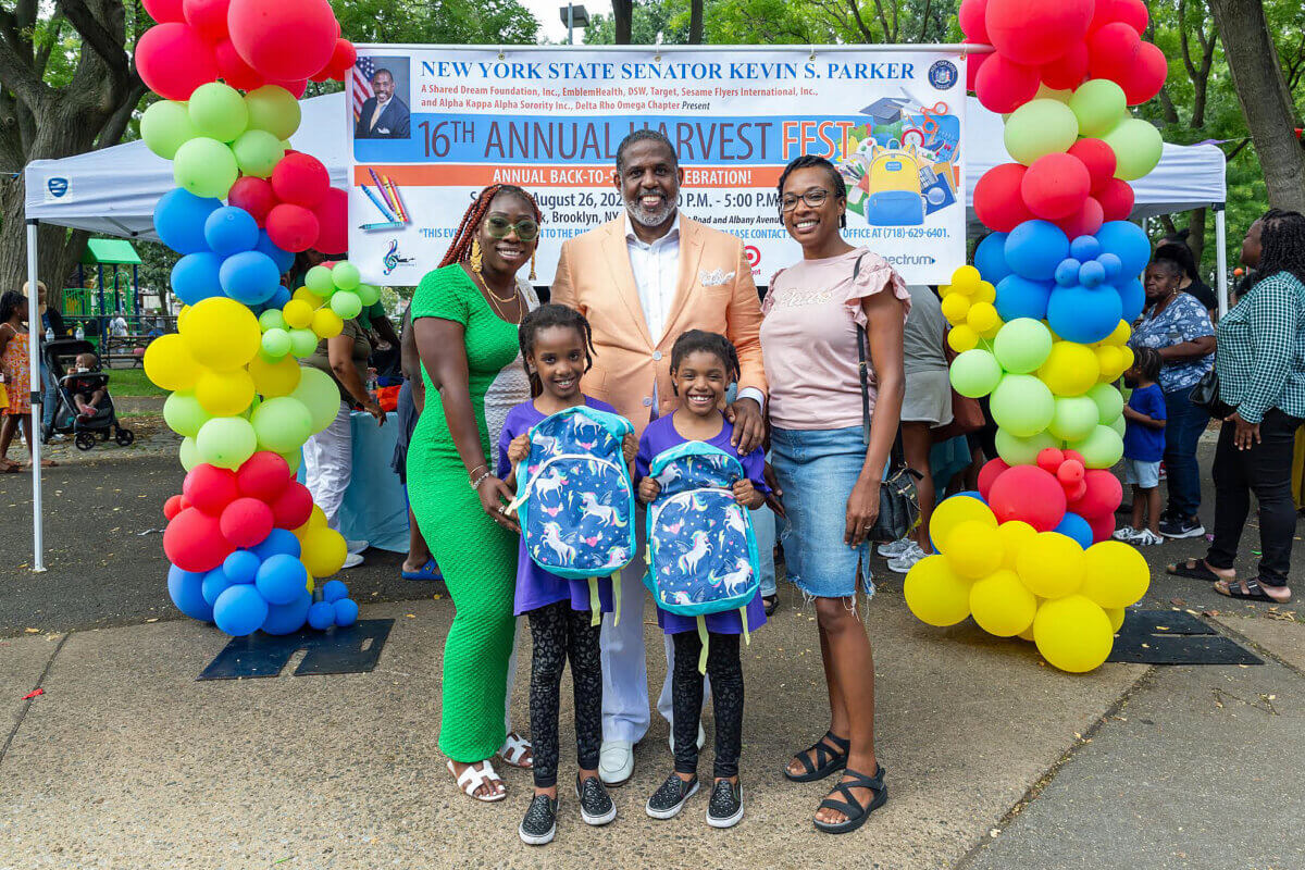 Senator Kevin Parker poses with students and parents after presenting them with backpacks at 16th Annual Back-to-School Harvest Fest, at Paerdegat Park, in the 21st Senate District, Brooklyn on Aug. 26, 2023.