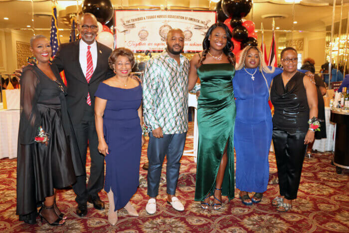 Scholarship recipient Leezana Lewis, fifth from left, in green dress, with presenters and President RN Thecla Williams, left, Mistress of Ceremonies Jean Leon, third from left, and Consul General Andre Laveau, second from left.