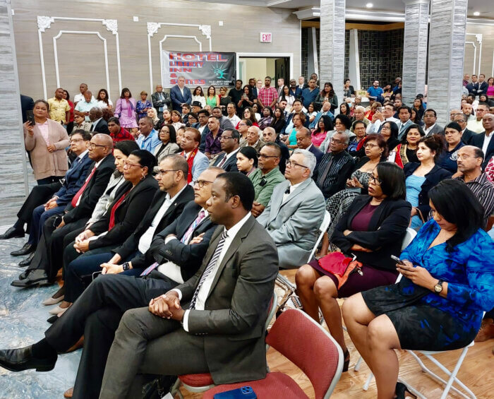 Part of an audience, with dignitaries and members of President Mohamed Irfaan Ali's delegation in the front row listens with rapt attention as the head of state addresses a diaspora town hall meeting at the Hotel Liberty Inn & Suites in Queens.