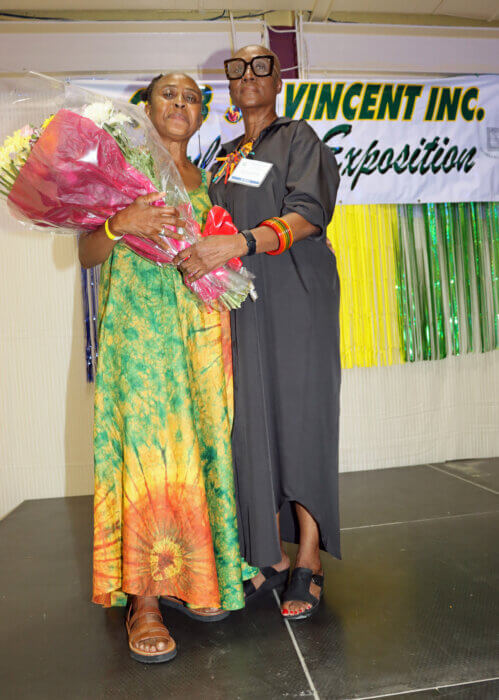Cornelia Arthur-Edwards, left, presents bouquet of flowers to her sister, Verna Arthur, exposition coordinator.
