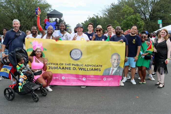 Public Advocate Jumaane Williams's wife, India Sneed Williams, with their 1-year-old child at left of Williams's banner. Williams is fourth from left with supporters.