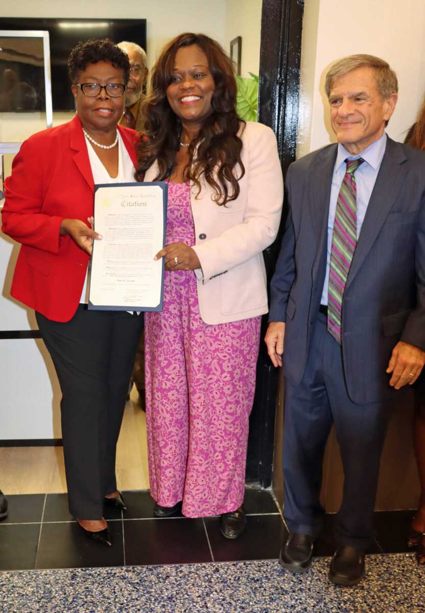 Dr. Jean Joseph, left, received citation from Assemblymember Rodneyse Bichotte Hermelyn, flanked by MC Benjamin Pinczewski, Esq., right.