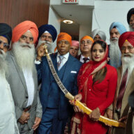 Assemblywoman Jenifer Rajkumar presents a kirpan to Mayor Eric Adams with members of the Sikh community looking on.