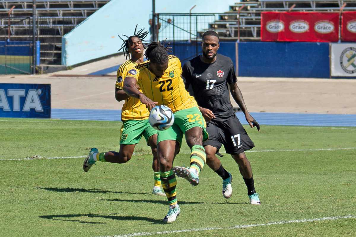 KINGSTON, JAMAICA Nov. 17: Gregory Leigh #22 of Jamaica kicks the ball and Cyle Larin #17 of Canada during the League A Quarter Finals match between Jamaica and Canada in the Concacaf Nations League, held at the National Stadium, Kingston, Jamaica.