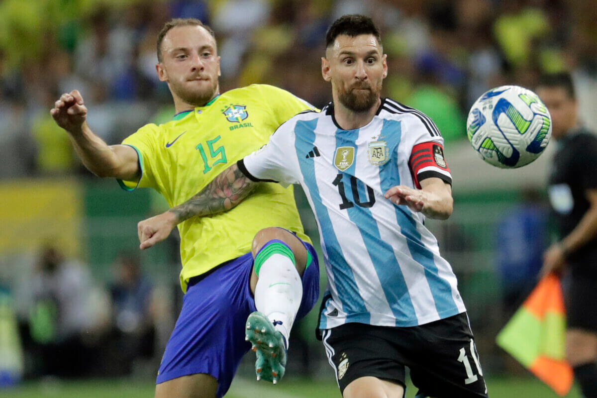 Argentina's Lionel Messi, right, and Brazil's Carlos Augusto battle for the ball during a qualifying soccer match for the FIFA World Cup 2026 at Maracana stadium in Rio de Janeiro, Brazil, Tuesday, Nov. 21, 2023