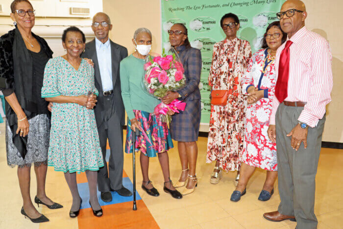Ela Toney, fourth from left, receives bouquet of flowers from Pastor Robert McBarnett, right, with his wife to his right, and Zita Adams, third from right, flanked by members of the Toney Family.