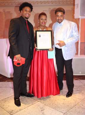 Francine Ross-Roden receives proclamation from House Democratic Leader Hakeem Jeffries, presented by Daniel Roden, Sr.,right, and flanked by their son, Daniel Roden, Jr.