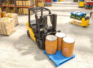 A forklift transports barrels inside a warehouse full of goods.