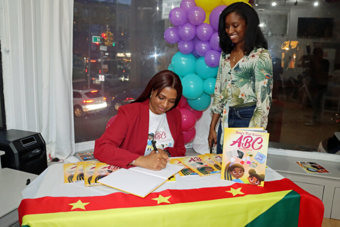 Dr. Ansha Clement signs ‘Baby’s First Science: ABC’ for Shavonne Pope.