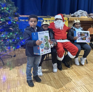 Children receive gifts and pose with Santa.