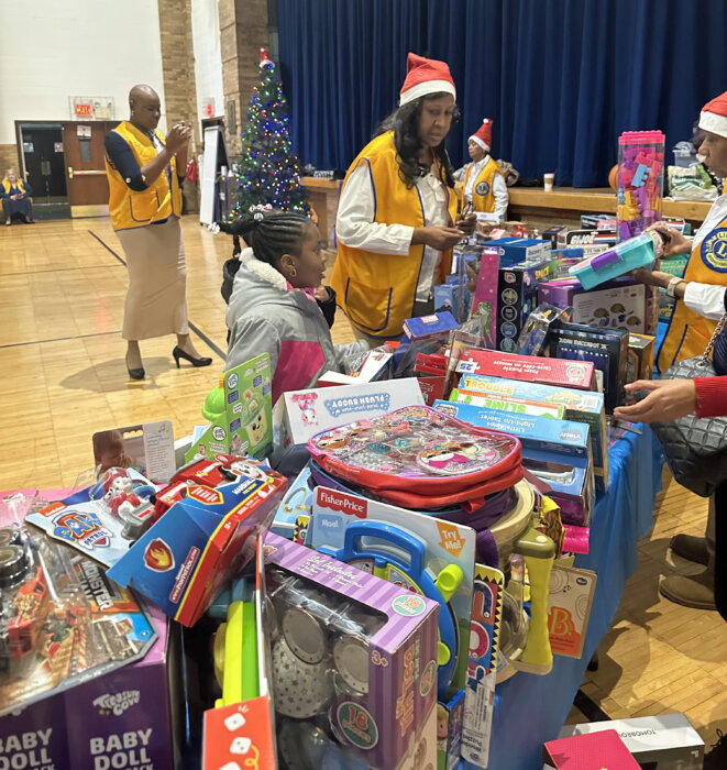 Lion Maria Nanton, center, helps a child select a holiday toy.