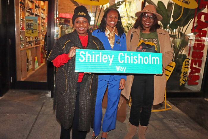 Displaying Shirley Chisholm Way signage,from left, Shelley Worrell, Assemblywoman Monique Chandler-Waterman and Nicole Robinson-Etienne.