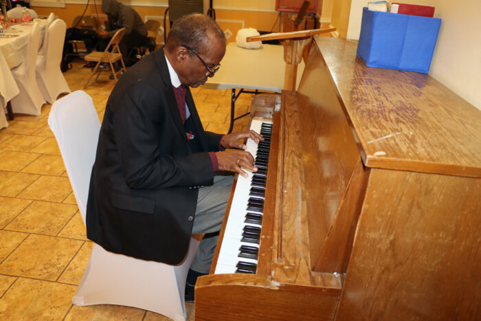 Belizean Jeffrey Adolphus backs up, on piano, Irlene Jones-Brathwaite as she sings "Every Praise to Our God.”