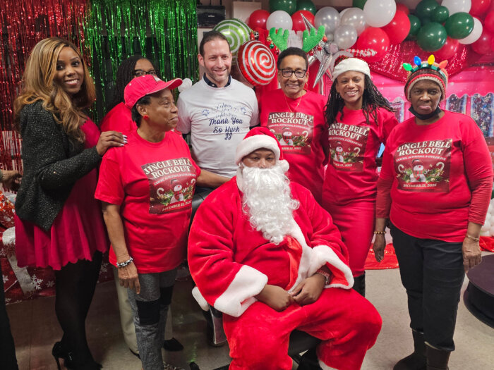 Council Member Farah N. Louis, left, and representatives from Clipper Realty and Flatbush Gardens pose for a photo with Santa Claus at Flatbush Gardens' Jingle Bell Rockout.