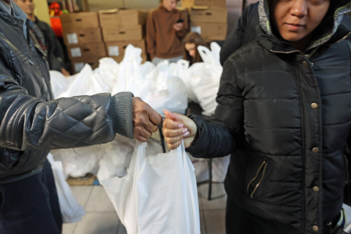 A woman receives a turkey for Thanksgiving from the Inwood Food Pantry.