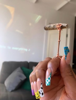 A cannabis cigarette on a golden holder.