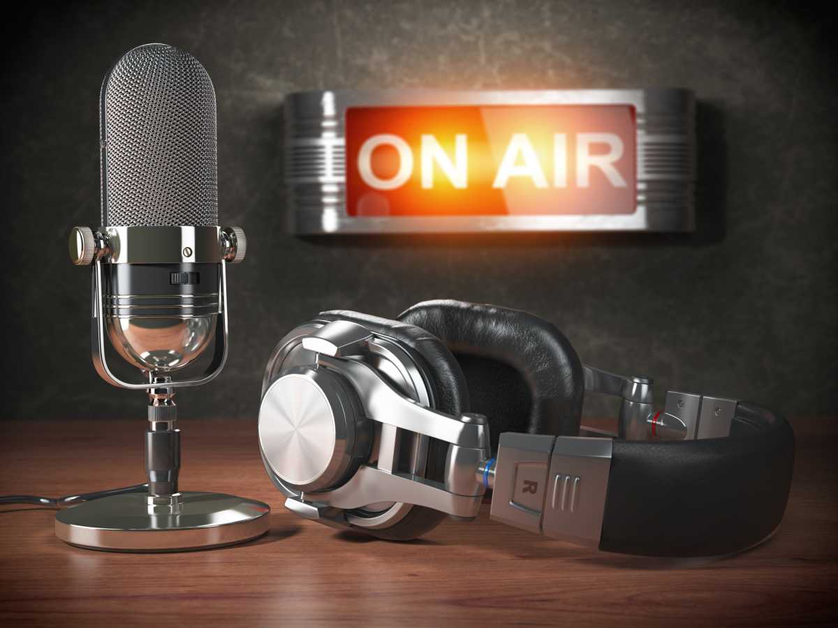 Vintage microphone  and headphones with signboard on air. Broadcasting radio station concept.