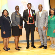 St. Vincent and the Grenadines Consul General to the United States Rondy "Luta" McIntosh, center, receives plague, on behalf of Vincentian Prime Minister Dr. Ralph E. Gonsalves, from Dr. Ken Irish-Bramble, to McIntosh's left, chair of Brooklyn's Medgar Evers College's (MEC) Caribbean Research Center, in June 2023 in commemorating Caribbean-American History Month at MEC. Others in photo from left: Horace Davis, president of Caribbean-American Society of New York; MEC Provost Dr. Antoinette Coleman; Sherrill-Ann Mason-Haywood, director of MEC's Seek Program; Dr. Evelyn Castro, senior advisor to MEC President Dr. Patricia Ramsey; and Anna Walker, representative of the Caribbean-American Chamber of Commerce and Industry (CACCI).