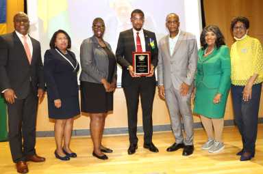 St. Vincent and the Grenadines Consul General to the United States Rondy "Luta" McIntosh, center, receives plague, on behalf of Vincentian Prime Minister Dr. Ralph E. Gonsalves, from Dr. Ken Irish-Bramble, to McIntosh's left, chair of Brooklyn's Medgar Evers College's (MEC) Caribbean Research Center, in June 2023 in commemorating Caribbean-American History Month at MEC. Others in photo from left: Horace Davis, president of Caribbean-American Society of New York; MEC Provost Dr. Antoinette Coleman; Sherrill-Ann Mason-Haywood, director of MEC's Seek Program; Dr. Evelyn Castro, senior advisor to MEC President Dr. Patricia Ramsey; and Anna Walker, representative of the Caribbean-American Chamber of Commerce and Industry (CACCI).