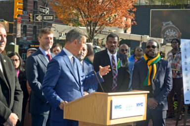 Commissioner Edward Mermelstein addresses unveiling ceremony, with CG McIntosh to his left.