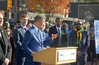 Commissioner Edward Mermelstein addresses unveiling ceremony, with CG McIntosh to his left.