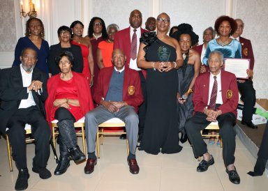 Claudette Thomas-Butler, fourth from left in black dress, holds plaque, flanked by Council Member Mercedes Narcisse, second row, right, and members of VINCI.