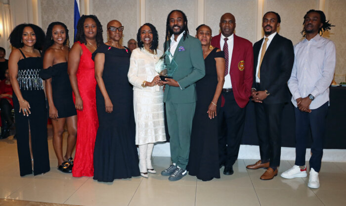 Atiba Edwards, sixth from left, holds plaque with Congresswoman Yvette D. Clarke, to his immediate right; his mom to his immediate left; aunt Verna Arthur, fourth from left; VINCI President Wayne Raguette, third from right; and other members of Edwards' family.
