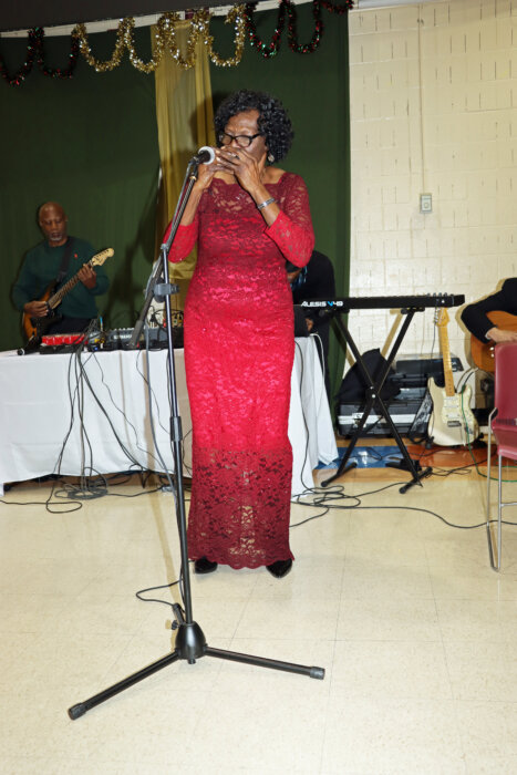 Emily Mentor James, 72, plays the harmonica.