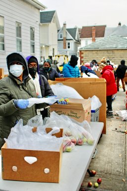 Volunteers diligently pack fruits and food items to be shared to migrants and residents who joined lines to be served at Calvary's Mission Food Pantry in Richmond Hill, Queens on cold Saturday, Jan. 6.