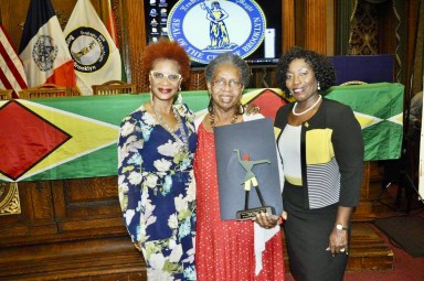 Caribbean Life freelance reporter, Tangerine Clarke, left, and retired Guyana Consul General of Guyana to New York, Barbara Atherly, congratulates Cultural Ambassador Claire A. Goring after she was honored with the 2016 GCA Lifetime Achievement Award at Brooklyn Borough Hall.
