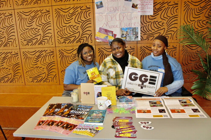 Damala Denny, manager of Youth & Alum Organizing, Girls for Gender Equity (GGE), left, joins college students, and youth coordinators, Khianna Deseide, and Heaven Peoples, at an activities table that shares information about GGE.